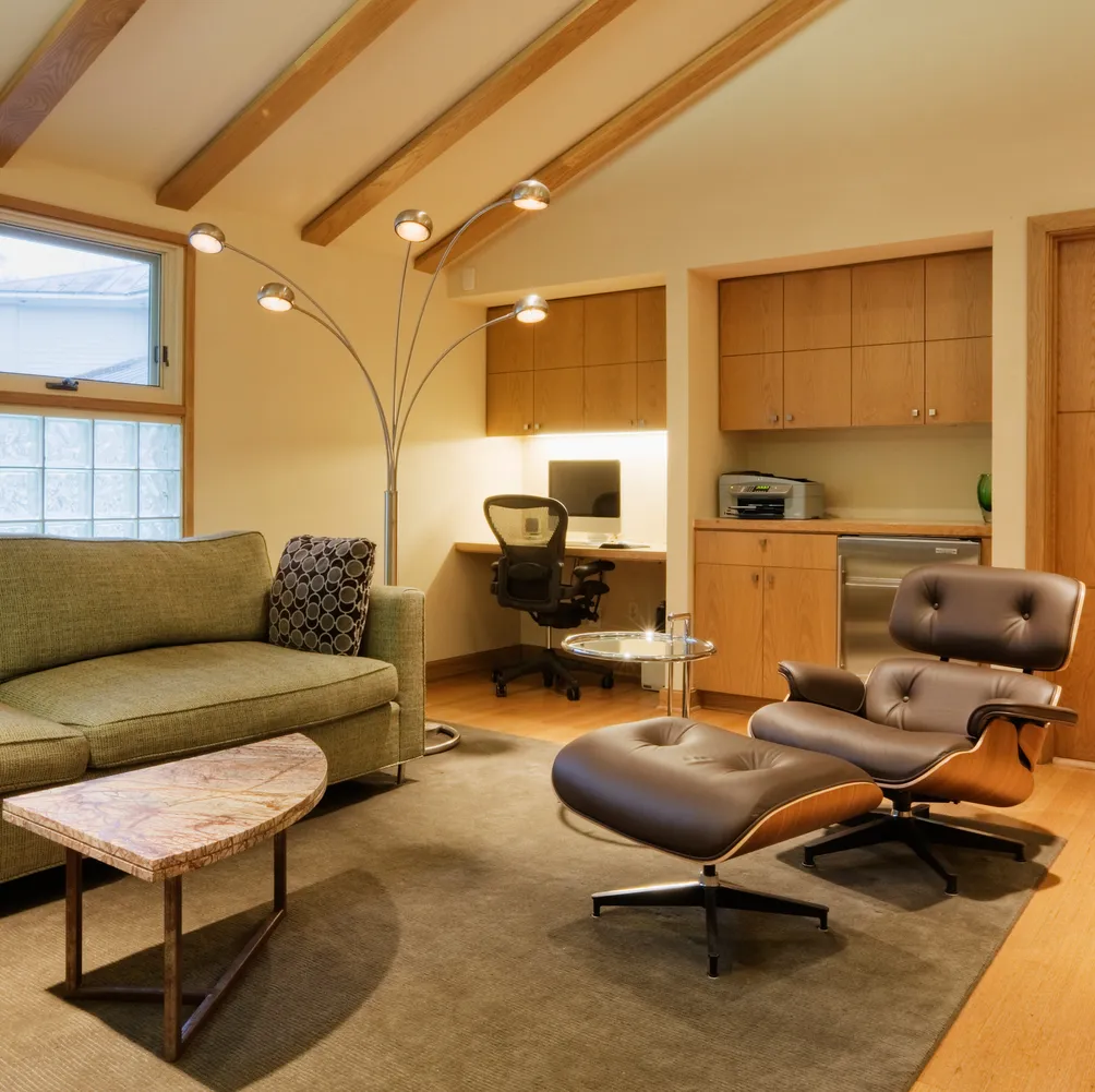 Staged living room with a lounge chair, sofa and desk