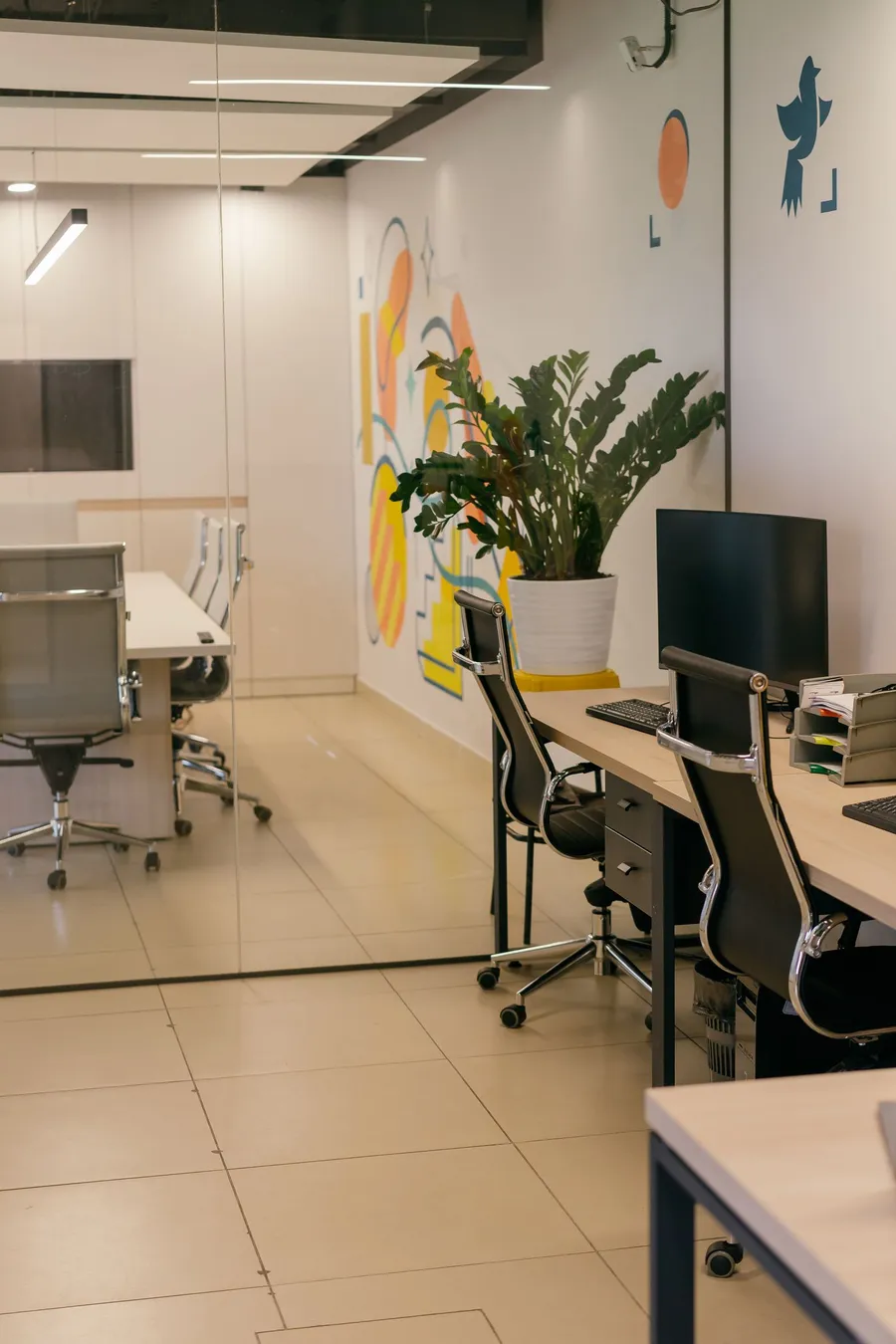 Modern commercial office interior with desks, task chairs and plants